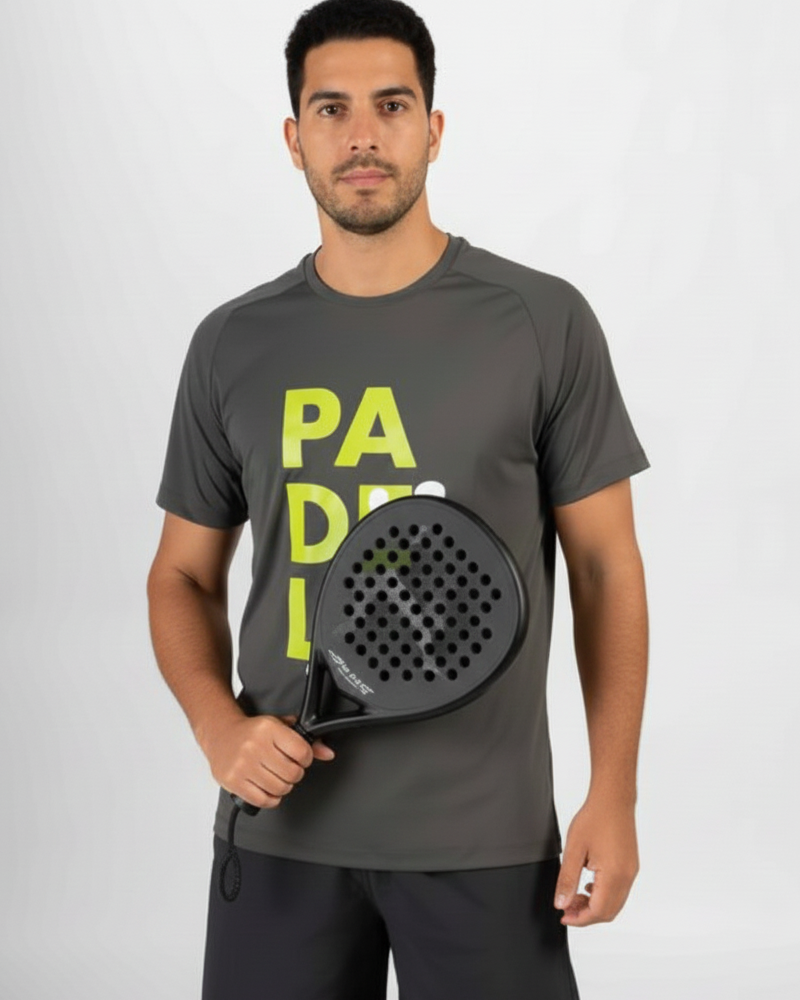Man holding a black paddle with 'Padel' text on a gray t-shirt against a white background
